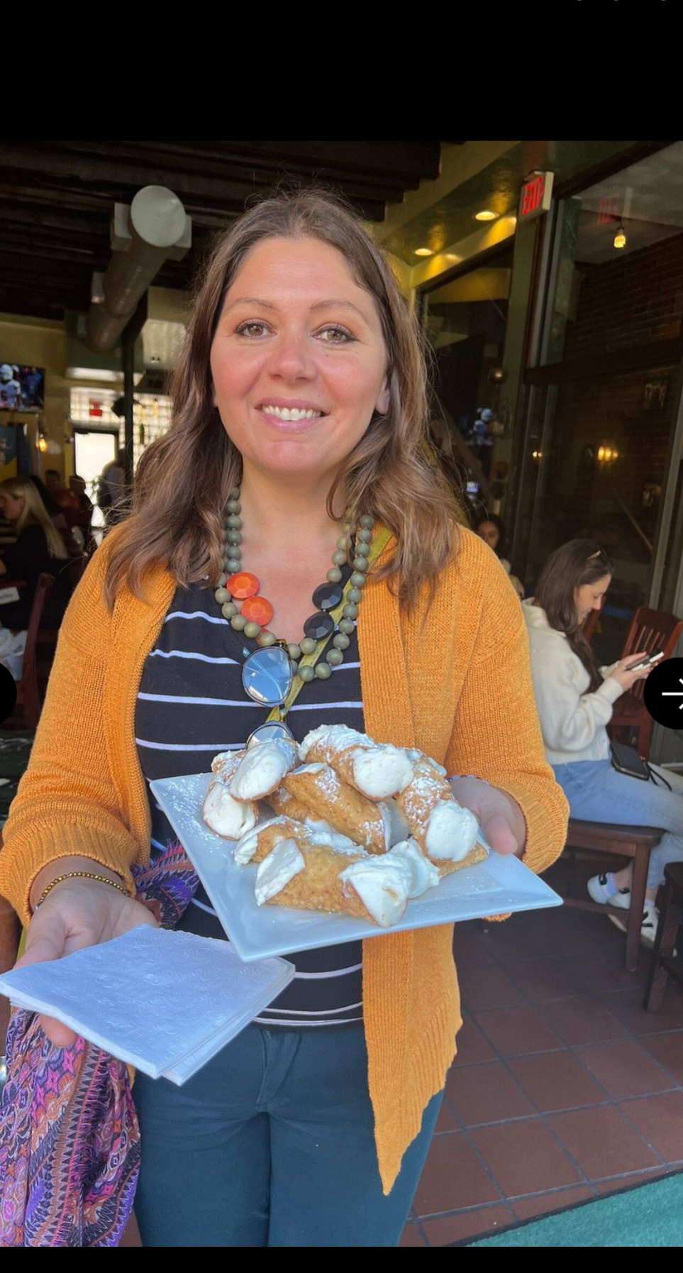 Paula with a North End baker beneath the Italian ingredient signs