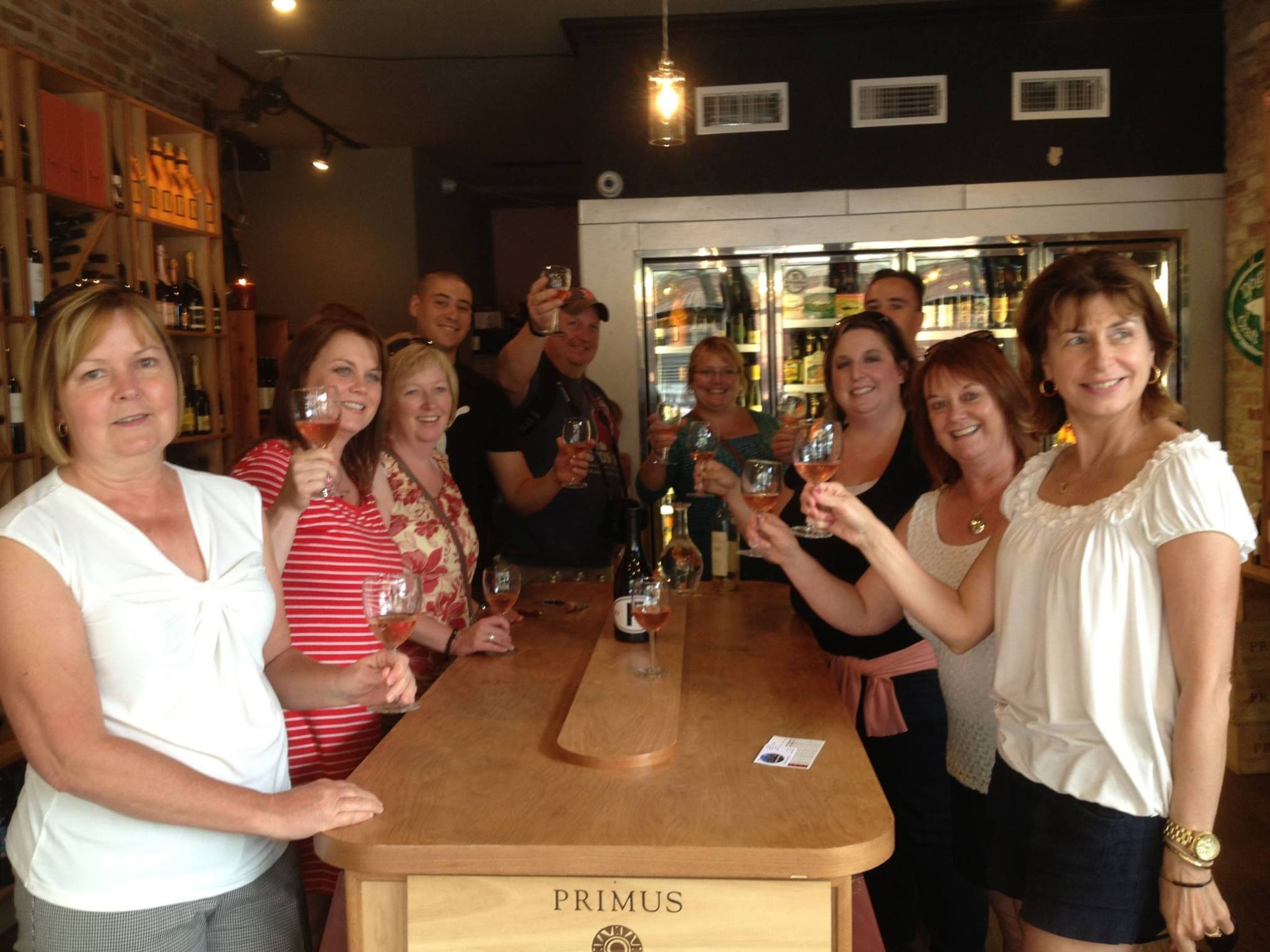 a group of people standing around a table with wine glasses